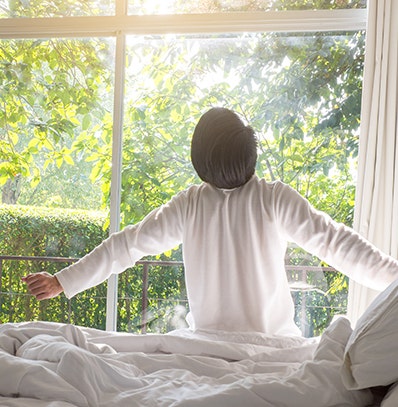 A woman stretching in the morning just after waking up. 