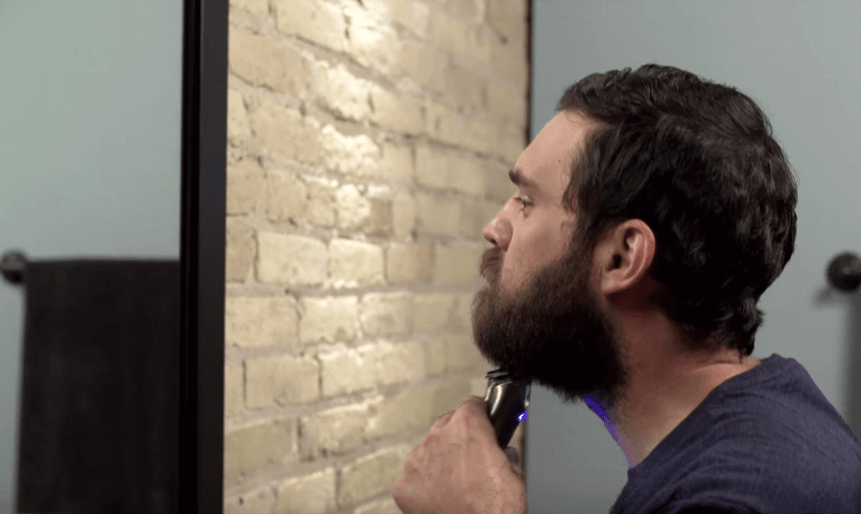 A man trimming his beard with a Wahl trimmer. 