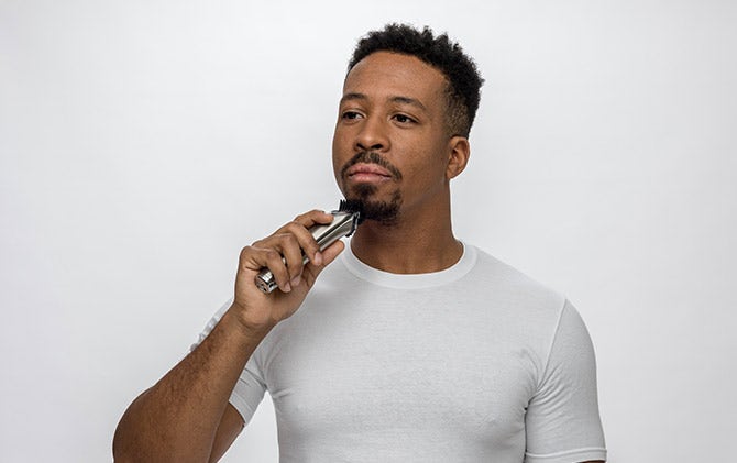 A man shaping his goatee with a Wahl trimmer. 