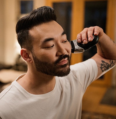 Man shaving with a Wahl electric shaver.