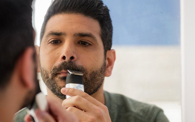 A man lining his mustache with a Wahl trimmer. 