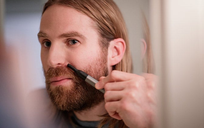 A man maintaining his facial hair between trims. 