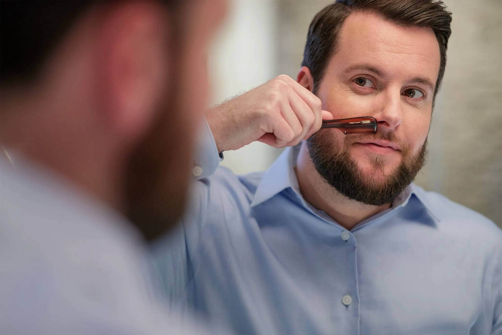 A man combing his mustache.