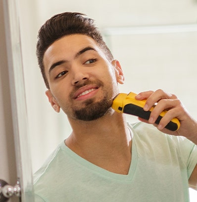 A man shaving with a Wahl electric shaver. 