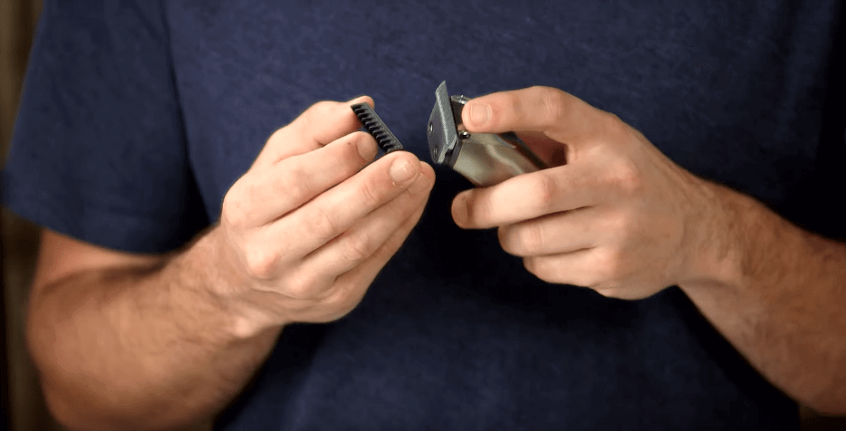 Someone attaching a guide comb to a Wahl beard trimmer.