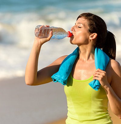 A woman drinking water after a workout.