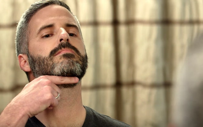 A man identifying where his beard line should start for lining his beard with a Wahl trimmer.