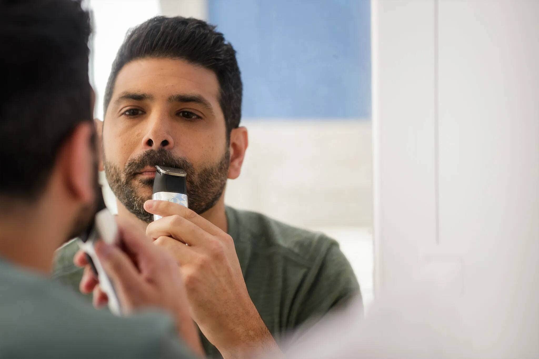 A man lining his mustache with a Wahl trimmer. 