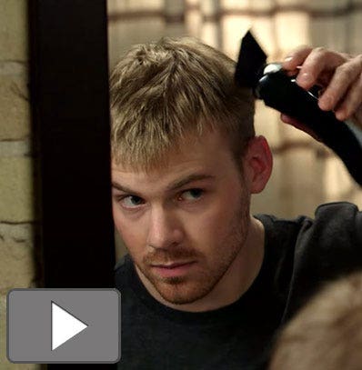 A man giving himself a haircut with a Wahl hair clipper. 