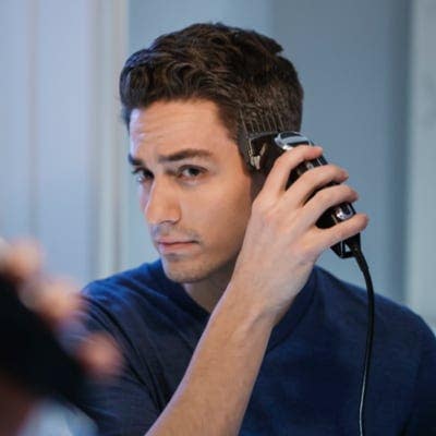 A man giving himself a tousled professional haircut with Wahl hair clippers. 