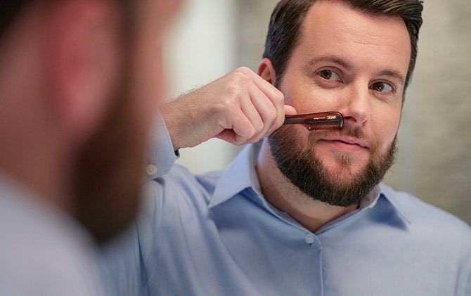 A man combing his mustache.